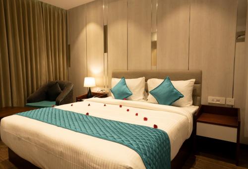 Cette chambre comprend un grand lit avec des oreillers bleus. dans l'établissement Gokulam Park Guruvayur, à Guruvāyūr