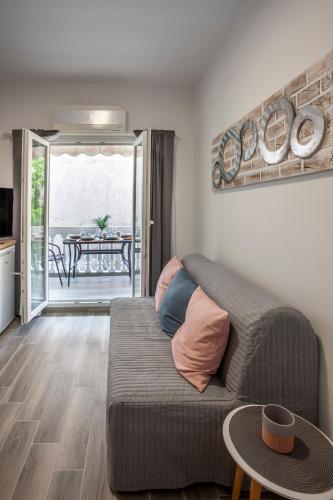 a living room with a couch and a table at Flamingo deluxe studio in Pefkochori