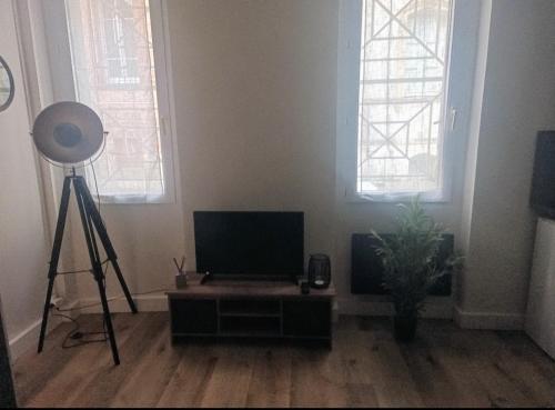 a room with a television and a tripod and two windows at Laurema's BnB in Toulouse