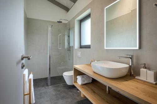 Un baño con lavabo, inodoro y espejo. en Villa Gala, en Kringa