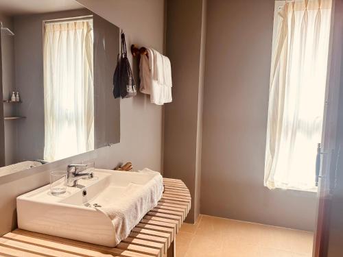 a bathroom with a white sink and a mirror at Goda Boutique Hotel in Hoi An