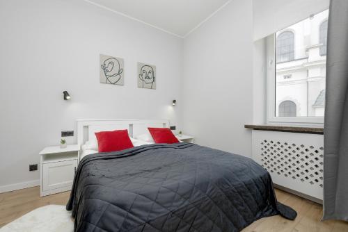- une chambre avec un lit et 2 oreillers rouges dans l'établissement Exclusive Grey and Red Apartment in Warsaw Center by Renters, à Varsovie