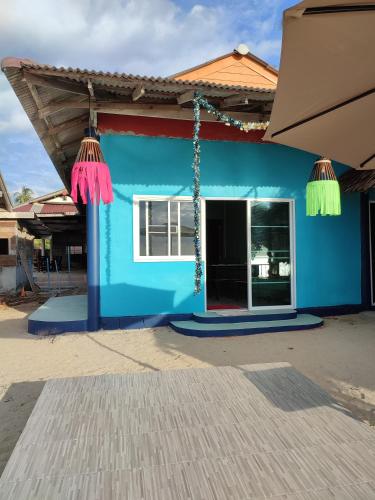 a blue building with tassels on it at Flower Apartment on the beach in Phra Ae beach