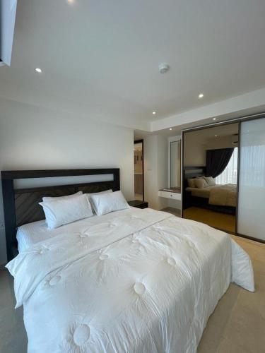 1 cama blanca grande en un dormitorio con espejo en Elegance and Comfort, en Christiansborg