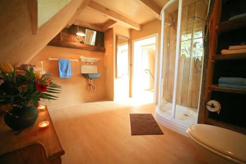 a bathroom with a shower and a vase of flowers at Ferienhaus Spreewaldnostalgie in Burg