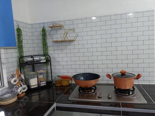 um balcão de cozinha com uma panela no fogão em D'RinduVillage Homestay em Marang