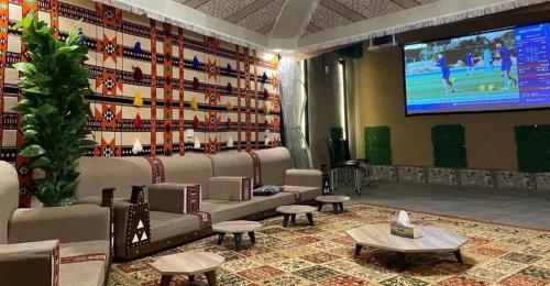 a lobby with couches and a large screen at Aya Hostel in Medina