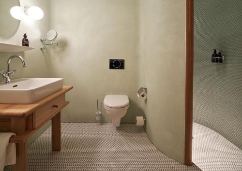 a bathroom with a sink and a toilet and a shower at kleiner Löwe – Stadthotel Bregenz in Bregenz