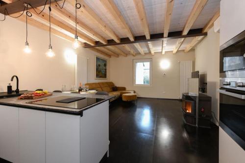 a kitchen with a counter top and a living room at Casa Margherita - new house in the ancient hamlet in Salò