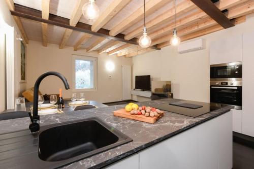 a kitchen with a sink and a counter with fruit on it at Casa Margherita - new house in the ancient hamlet in Salò