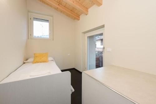 a white room with a bed and a window at Casa Margherita - new house in the ancient hamlet in Salò
