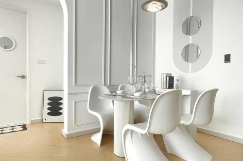 a white dining room with a table and white chairs at Dooga Ins-Dreamspace L37 Seaview Projector 1-6pax in Johor Bahru