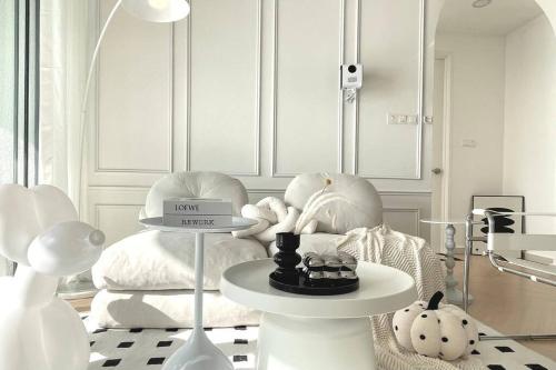 a room with white furniture and a table withumedumed objects at Dooga Ins-Dreamspace L37 Seaview Projector 1-6pax in Johor Bahru