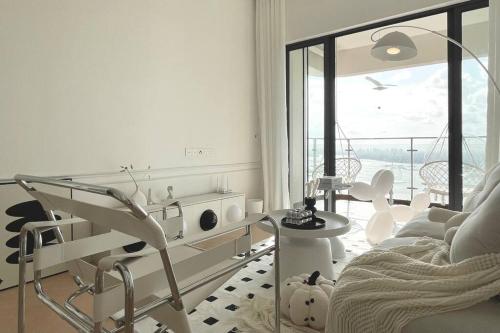 a white living room with a chair and a table at Dooga Ins-Dreamspace L37 Seaview Projector 1-6pax in Johor Bahru