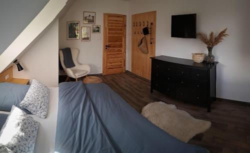a bedroom with a bed and a dresser with a television at CHALUPA U ROUBÍČKŮ in Horní Bečva