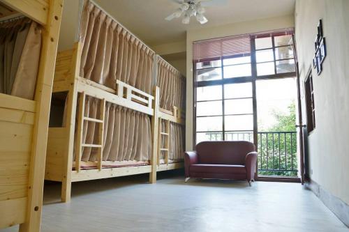 a room with two bunk beds and a chair at 打狗灣青年旅店 in Kaohsiung