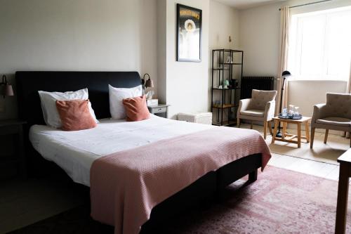 a bedroom with a large bed with pink pillows at Porta Cité in Maasmechelen