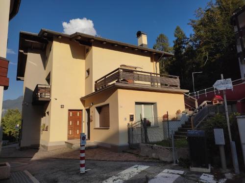 a house with a balcony on top of it at Casetta gialla in Pieve di Cadore