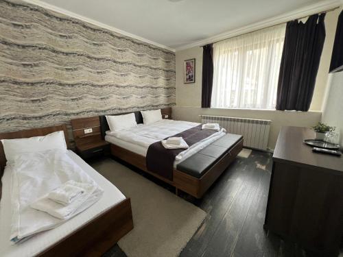 Pokój hotelowy z 2 łóżkami i biurkiem w obiekcie Vila Casa cu Tei w mieście Lupeni