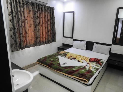 a small bedroom with a bed and a sink at Hotel Shri Sai Darshan in Shirdi