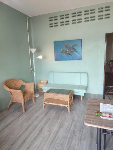a living room with a blue couch and two chairs at Flower Apartment on the beach in Phra Ae beach