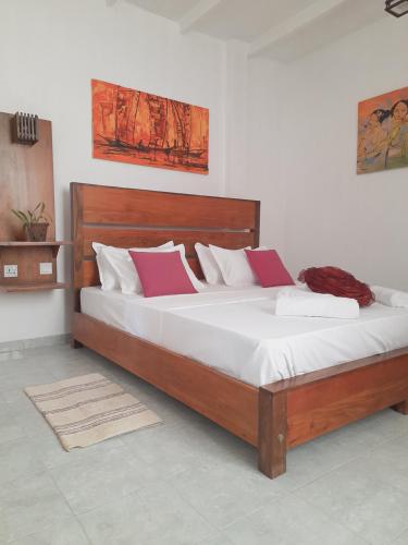a bedroom with a large bed with two pillows at Moon Deck Villa in Katunayake