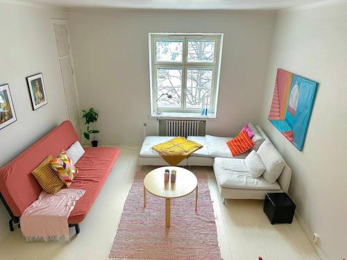 a living room with two couches and a table at Cute loft by Tram Stop in Helsinki