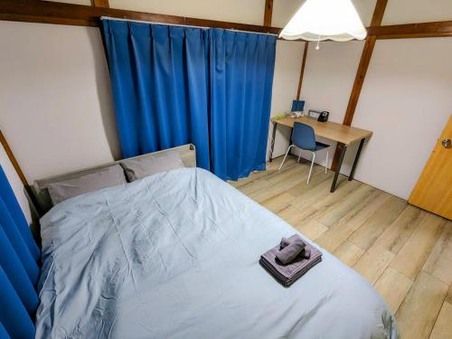 a bedroom with a bed with a desk and a table with a chair at SquareHouse Nishiarai in Tokyo