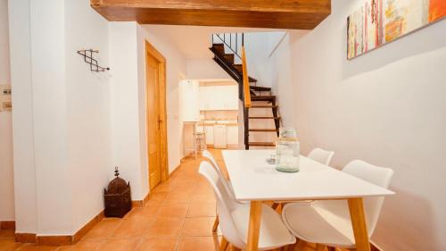 Un comedor con una mesa blanca y sillas blancas. en PRECIOSO DúPLEX PLAZA NUEVA, en Granada