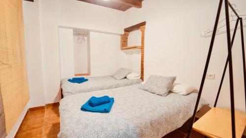 Habitación con 2 camas y toallas azules. en PRECIOSO DúPLEX PLAZA NUEVA, en Granada