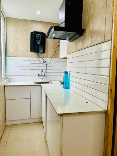 a kitchen with a sink and a microwave at The Cozy Cool Cabin in Dehradun