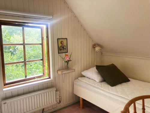a small bedroom with a bed and a window at Sövröds Hage in Höör
