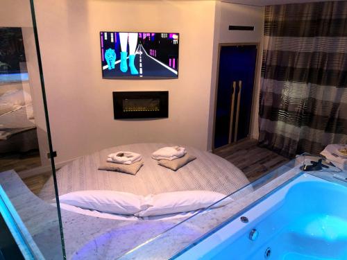 a bathroom with a tub with towels and a tv at LOFT CON SPA PRIVATA in Santa Maria degli Angeli