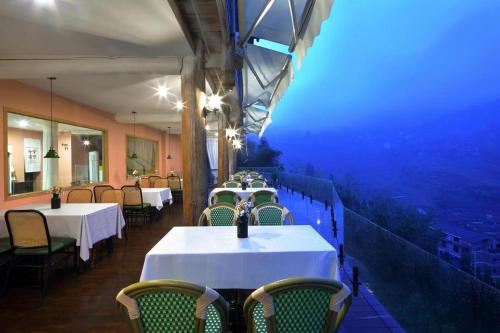 a dining room with tables and chairs with a view at Lost In Beauty Guest House 龙脊梯田野望民宿 in Longsheng