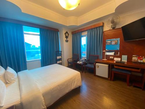um quarto de hotel com uma cama e uma secretária com um computador em A25 Hotel - 221 Bạch Mai em Hanói