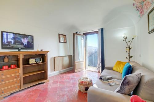 a living room with a couch and a tv at Dogliani Borgo Castello - Happy Rentals in Dogliani