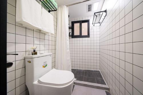 uma casa de banho branca com um WC e um chuveiro em Shanghai Hills&Well-time Homestay Fuxing em Xangai