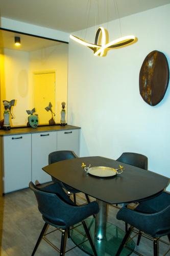a dining room with a table and chairs and a kitchen at Skyview Luxury appartement à Montevrain in Montévrain