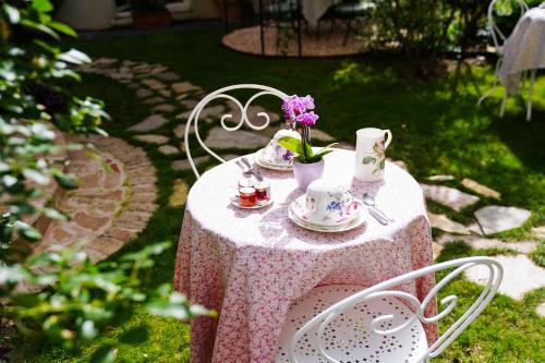 a table with a pink table cloth and cups and saucers at Villa Escudier Appart-hôtel in Boulogne-Billancourt
