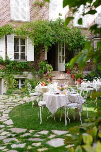 a table and chairs in front of a house at Villa Escudier Appart-hôtel in Boulogne-Billancourt