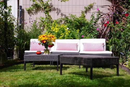a white couch sitting on a table in the grass at Villa Escudier Appart-hôtel in Boulogne-Billancourt