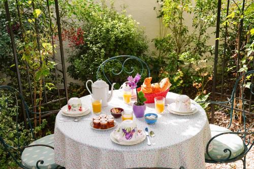 a table with food and drinks on top at Villa Escudier Appart-hôtel in Boulogne-Billancourt
