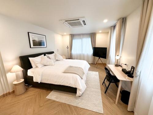 バンコクにあるUpscale 3-bedroom 3-bathroom suite 1 min to BTS Prompongのベッドルーム(ベッド1台、デスク、テレビ付)