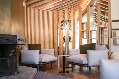 a living room with two chairs and a fireplace at Riffelalp Resort 2222m Ski-in & Ski-out in Zermatt
