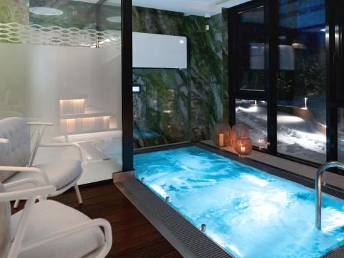 uma banheira de hidromassagem num quarto com uma grande janela em Holistic Skin & Wellness SPA Apartments em Birstonas