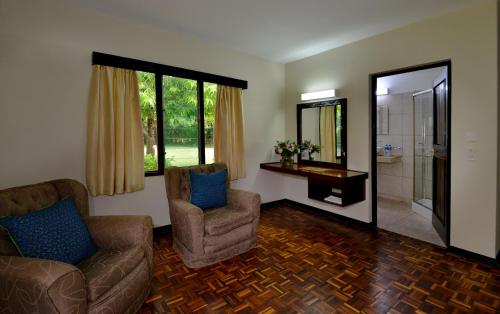 a living room with two chairs and a shower at Mnarani Beach Club in Kilifi