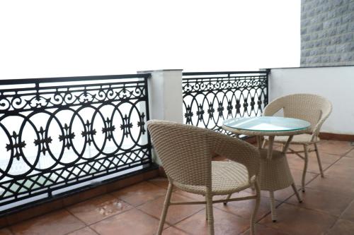 a patio with chairs and a table on a balcony at Rosetum Kasauli in Kasauli