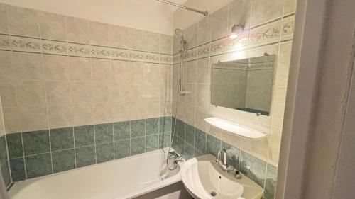 La salle de bains est pourvue d'un lavabo, de toilettes et d'une baignoire. dans l'établissement Deux pièces Ris Orangis, à Ris-Orangis