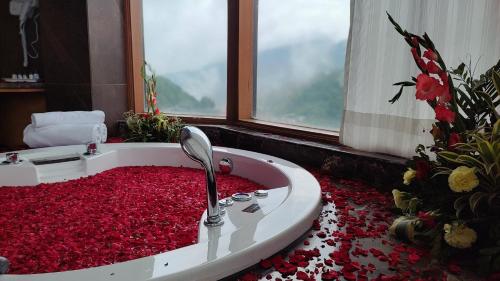 a bathroom with a tub full of red flowers at Rosetum Kasauli in Kasauli