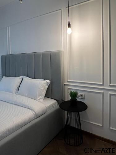 a small bedroom with a bed and a table at CineArte Residence in Caransebeş